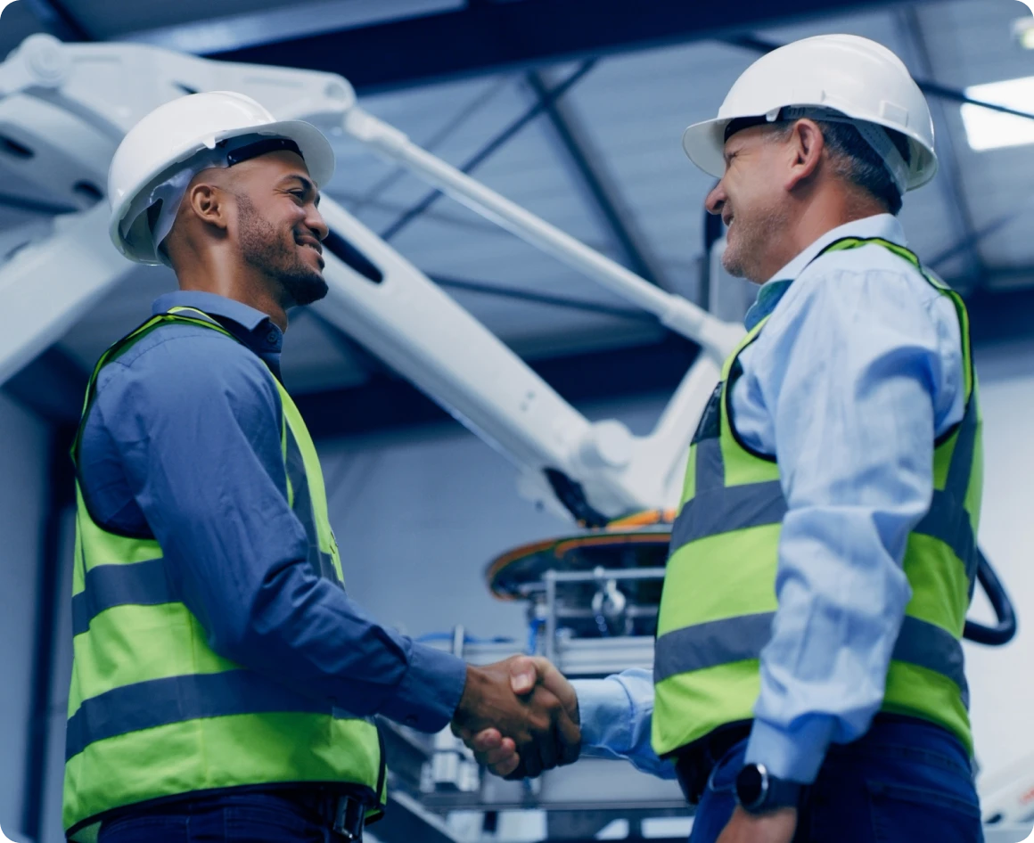 Engineers shaking hands in factory
