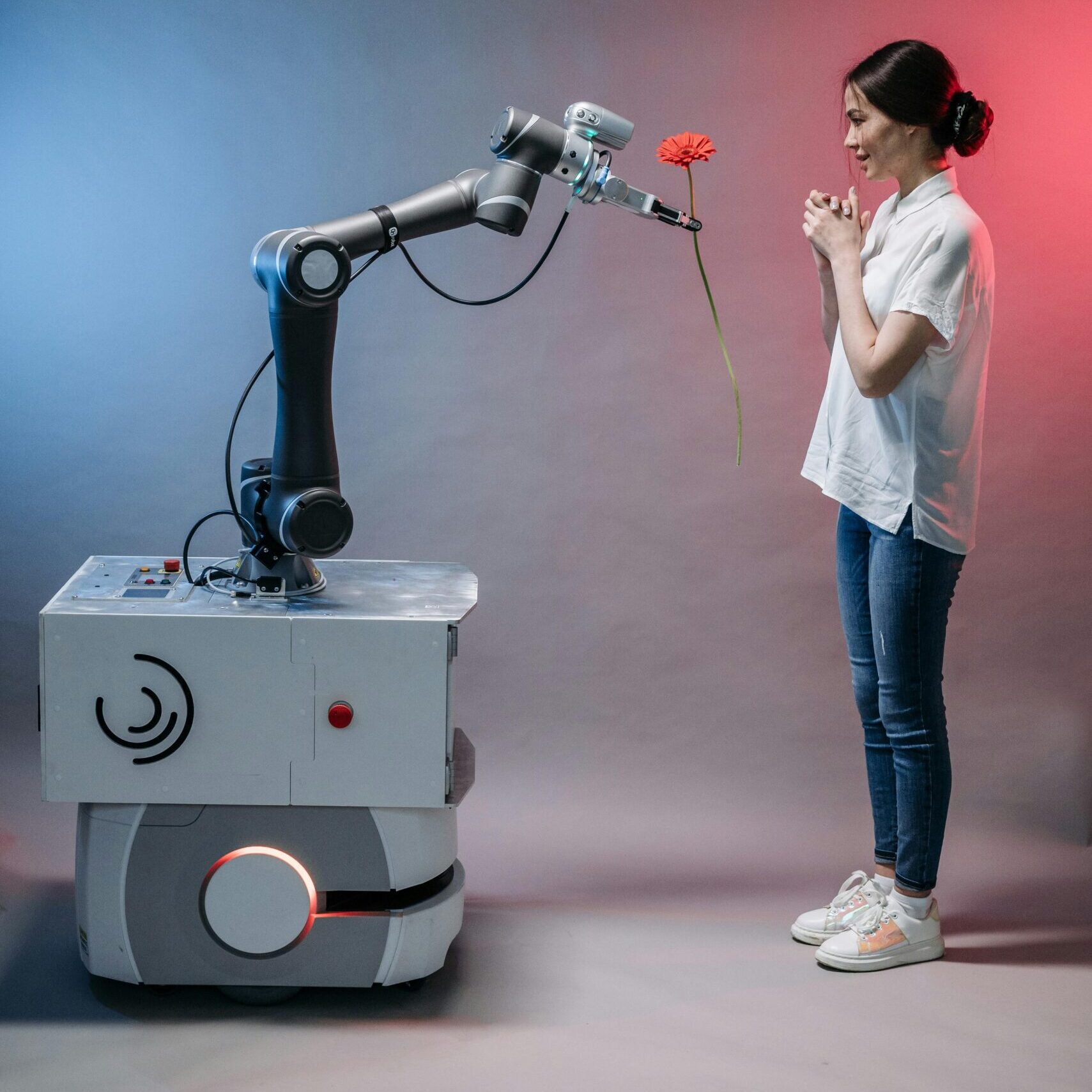 Robot presents a flower to a woman in a gentle interaction.